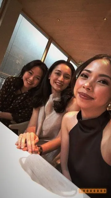 Three friends taking a selfie at a wedding dinner